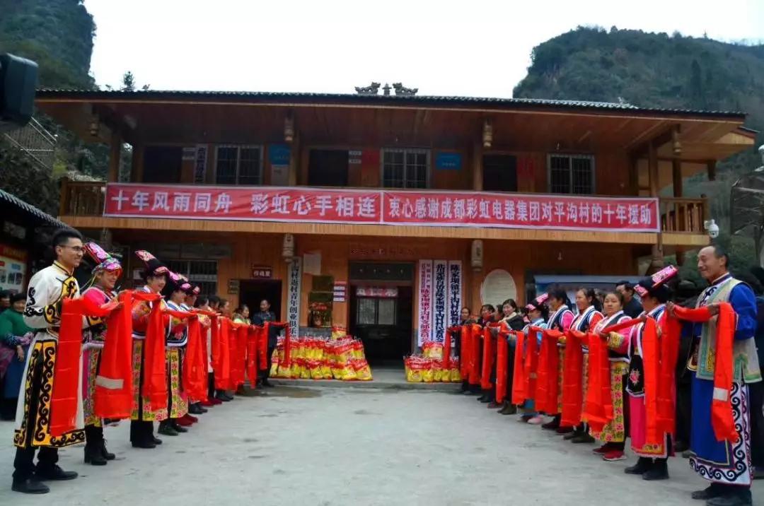 怀感恩之心，平沟村村民手持羌红在米兰MILAN(中国)公司援建的平沟村便民服务楼前热情等待米兰MILAN(中国)亲人们的到来